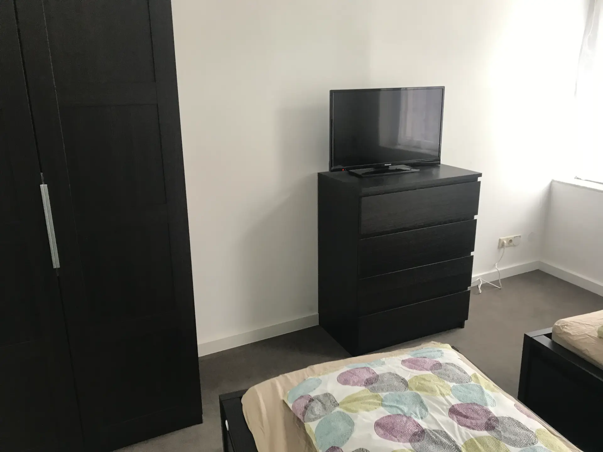 Schlafzimmer mit TV und Kleiderschrank