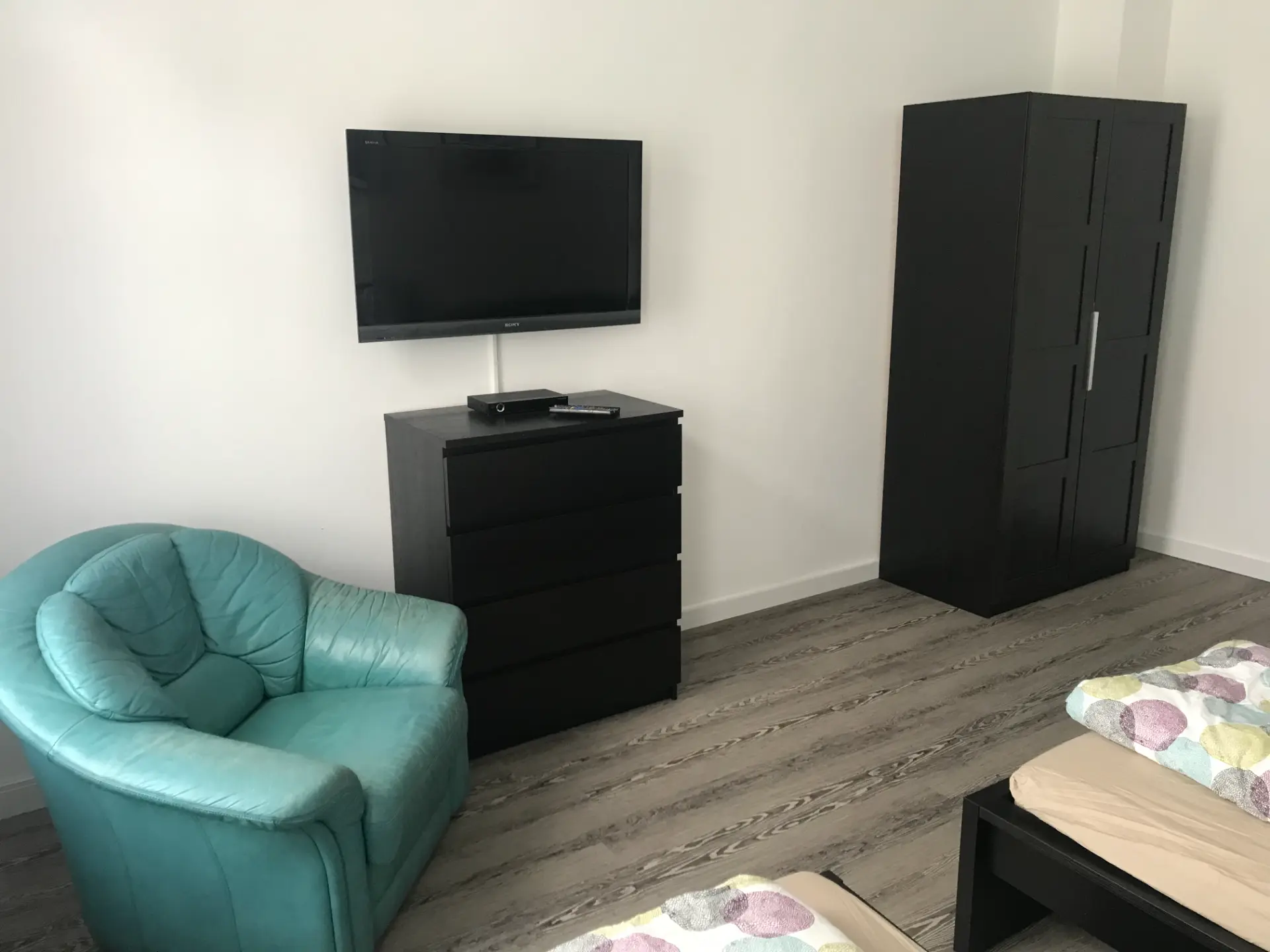 Schlafzimmer mit TV auf Kommode und Kleiderschrank