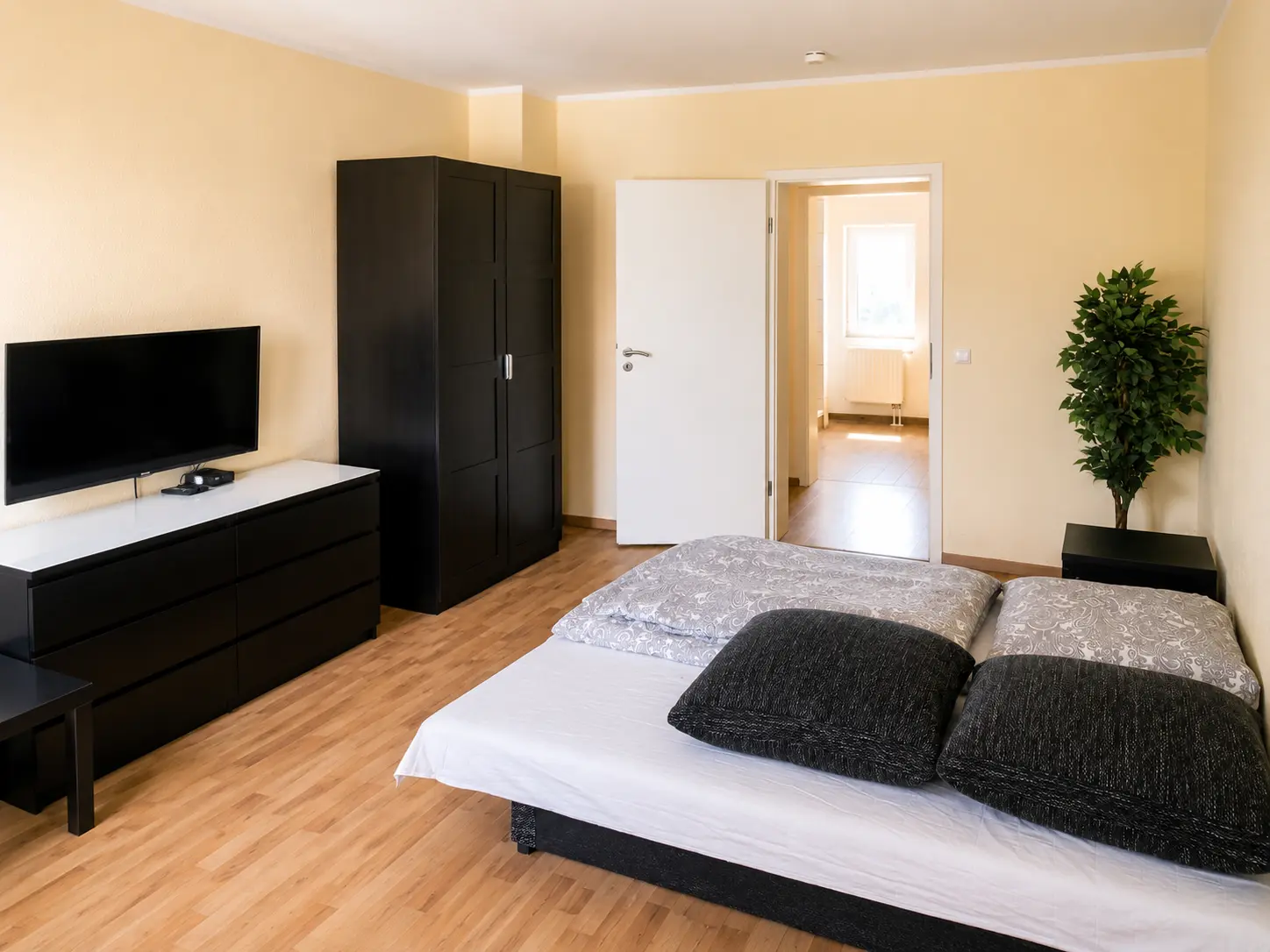Schlafzimmer mit Doppelbett, Kommode und Flachbild-TV