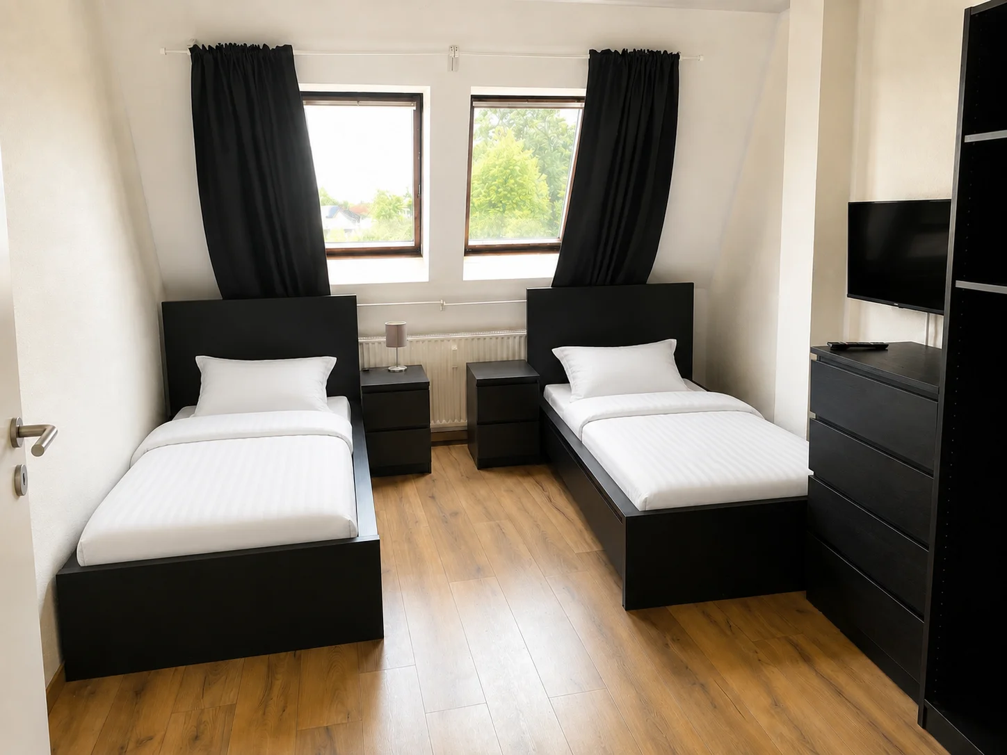 Schlafzimmer mit zwei Einzelbetten und TV
