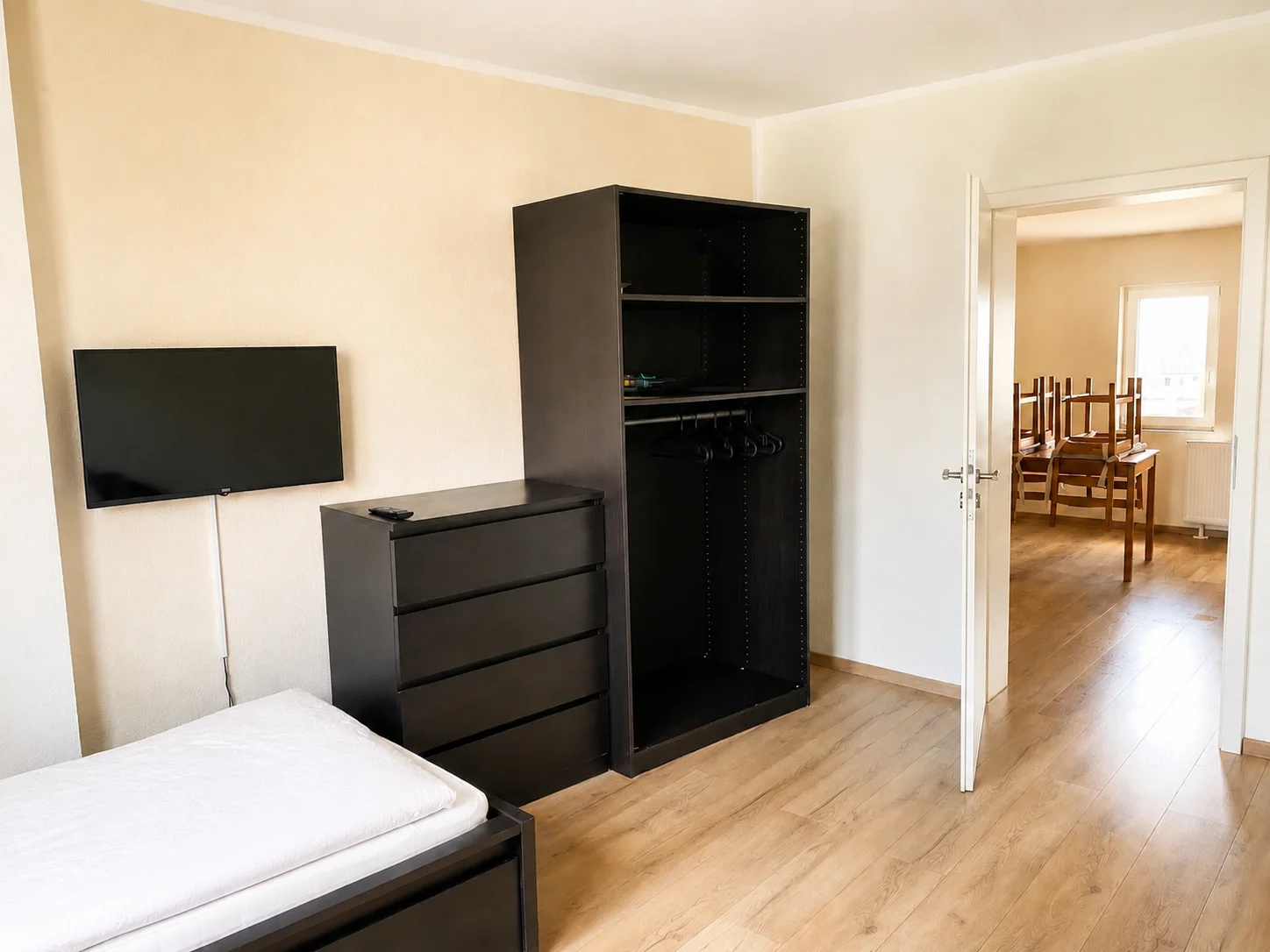 Schlafzimmer mit Einzelbett, TV und Kleiderschrank