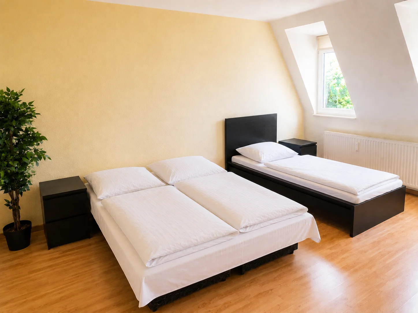 Schlafzimmer mit Doppelbett und Einzelbett, Zimmerpflanze