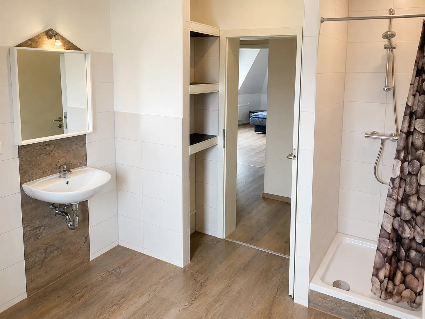 Badezimmer mit Waschbecken, Spiegel und Dusche