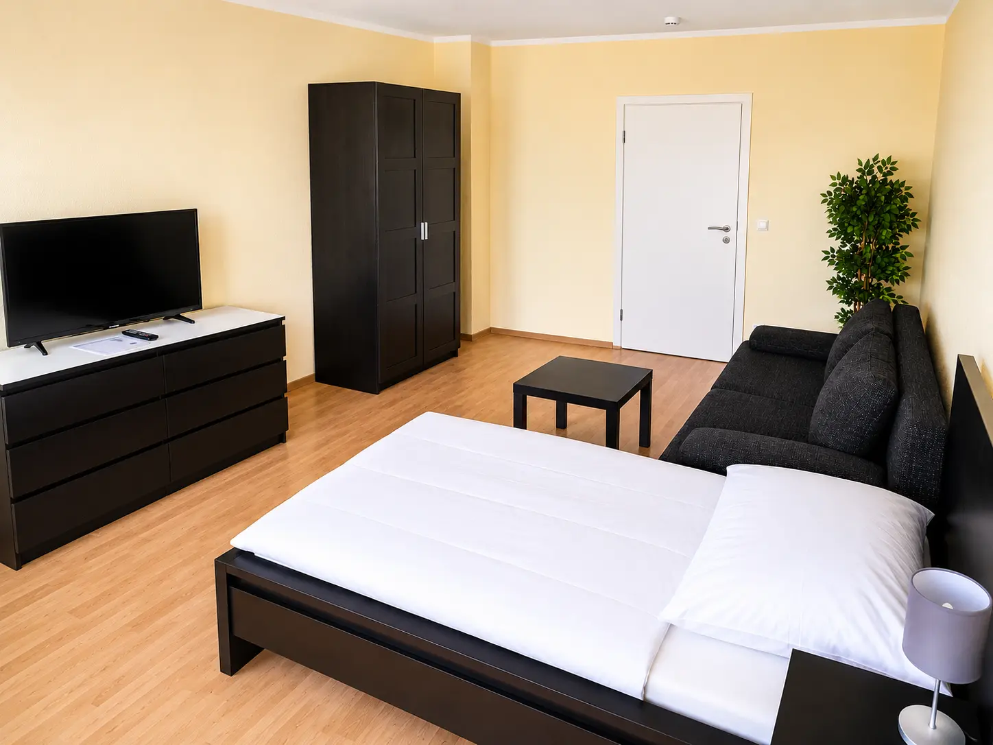 Geräumiger Wohnbereich mit Bett, Sofa und Kleiderschrank