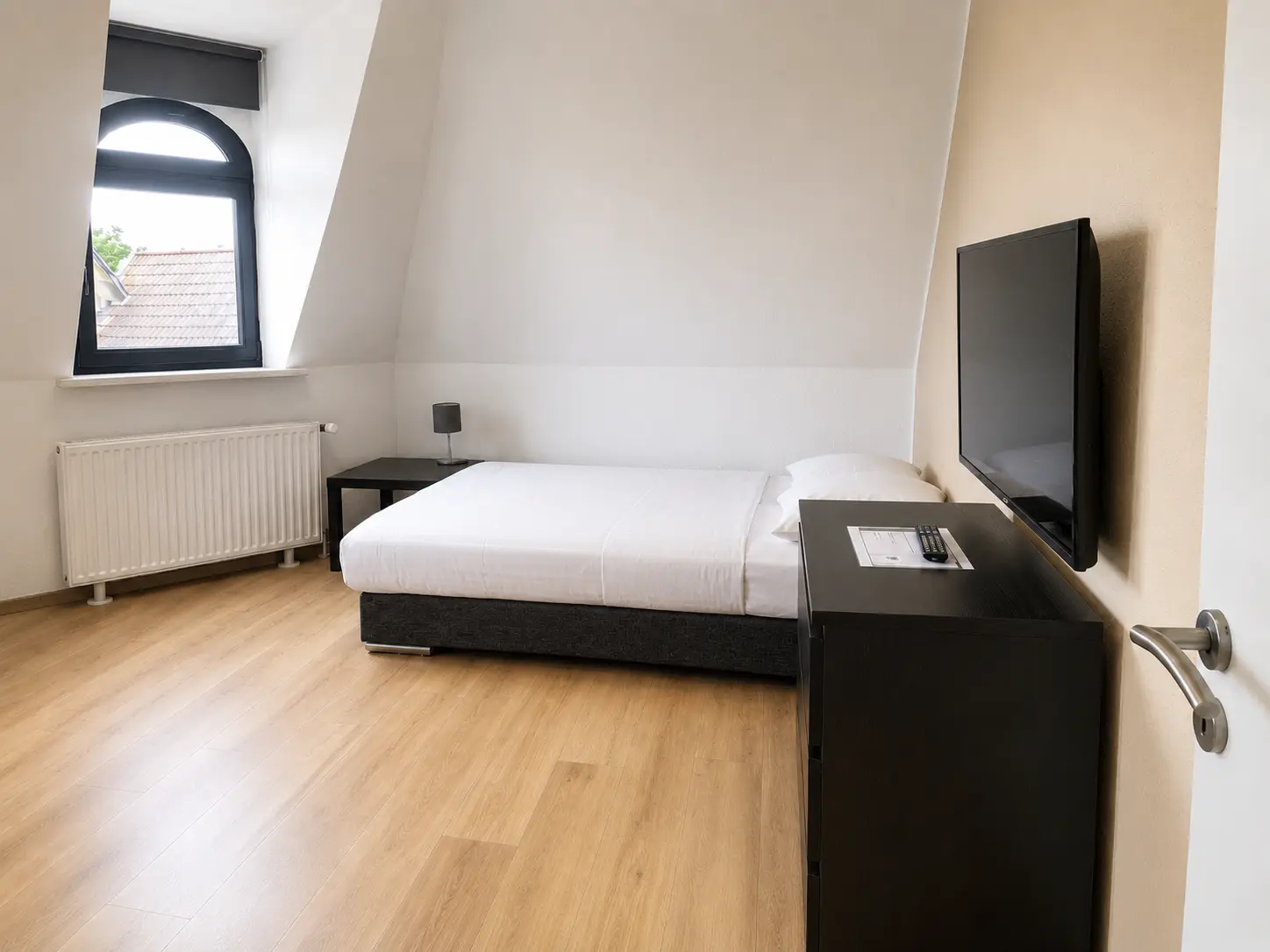 Schlafzimmer mit Bett und Wand-TV