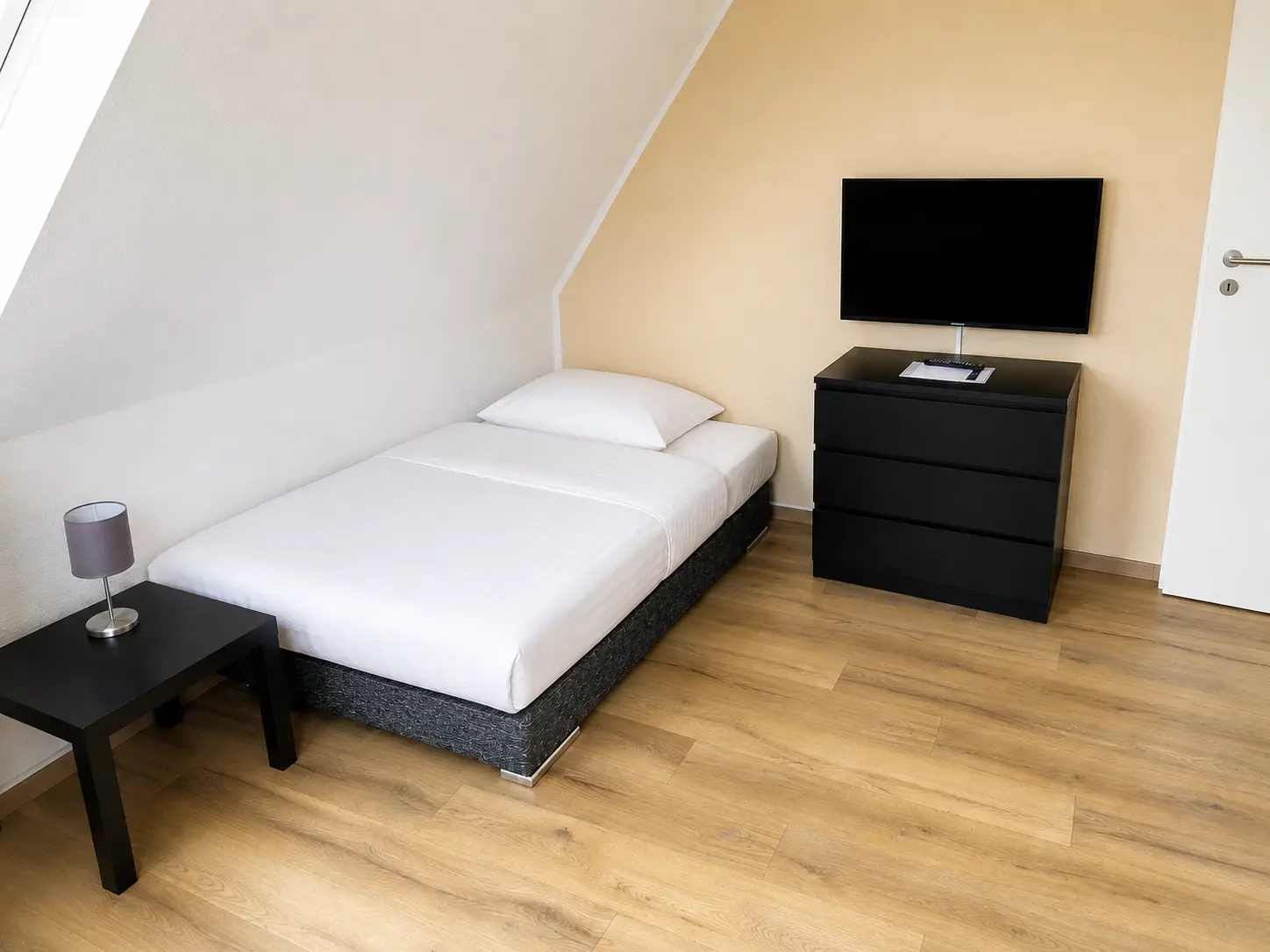 Schlafzimmer mit Bett, Kommode und Flachbild-TV