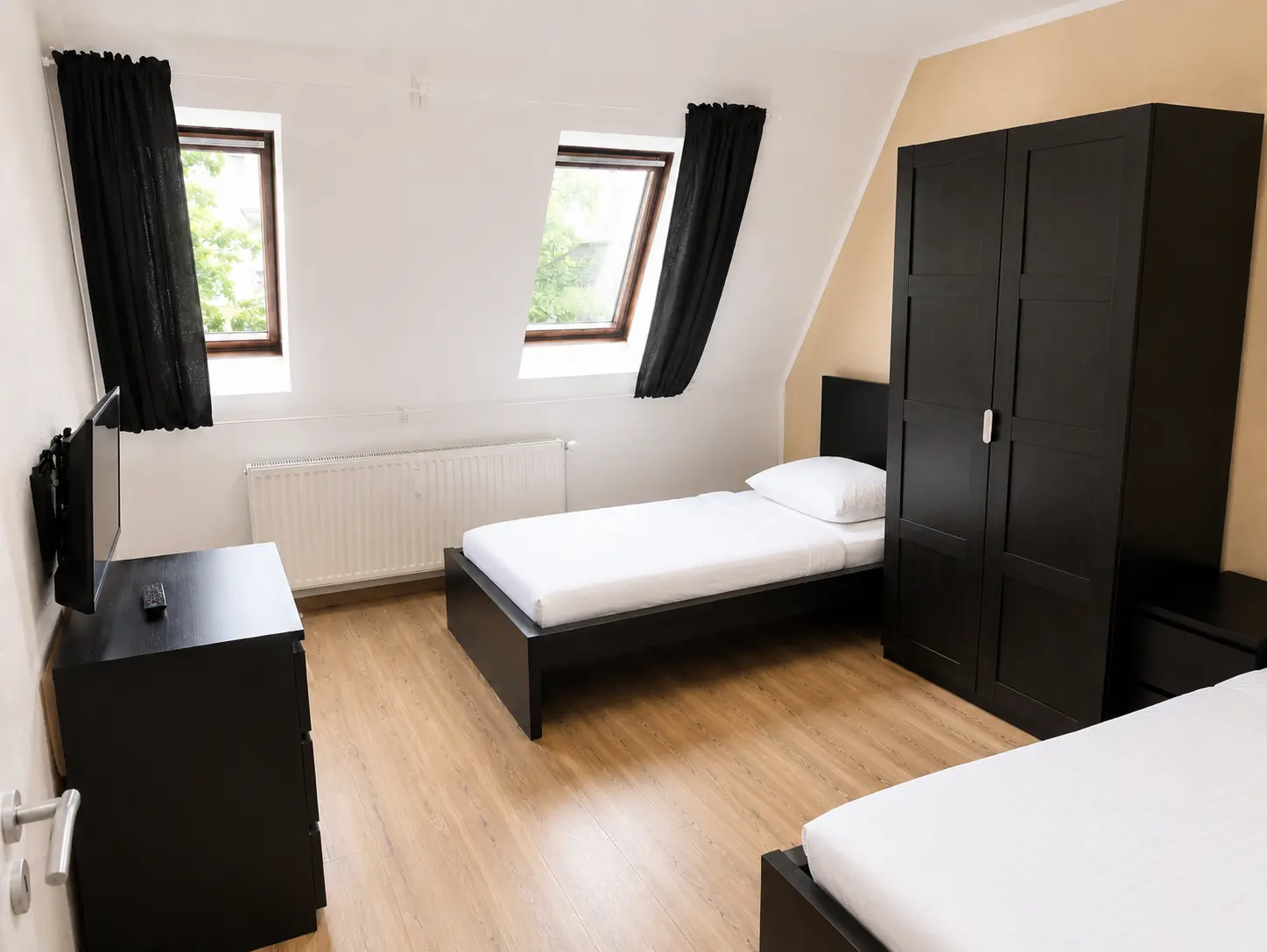 Schlafzimmer mit Einzelbett, Kleiderschrank und Dachfenstern