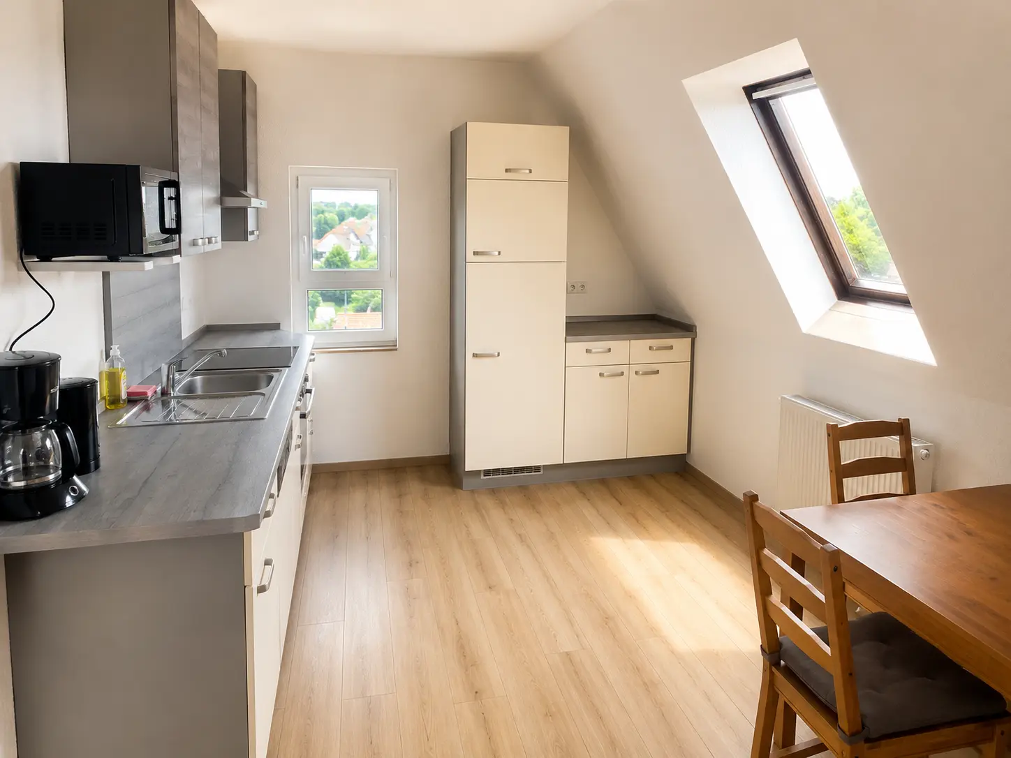 Küche mit Spüle, Kühlschrank und Dachfenster